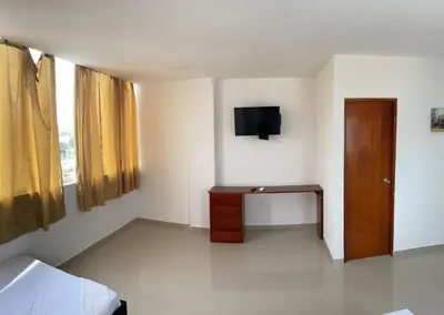 a room with a bed and a desk and a television at Apartamento 402 in Cartagena de Indias