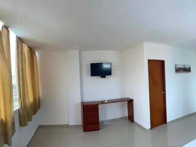 a room with a tv on the wall and a table at Apartamento 402 in Cartagena de Indias