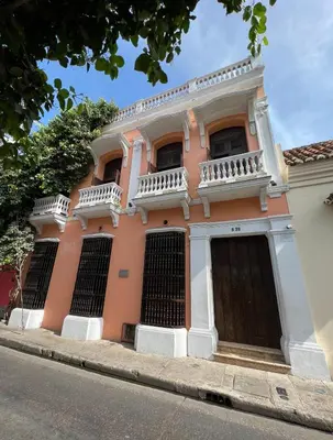 a pink building with a balcony on a street at Loft en Casa Colonial del Centro Histórico de Cartagena in Cartagena de Indias
