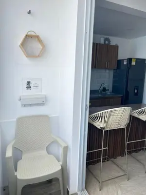 a room with a chair and a table and a kitchen at Coveñas Apartamento vacacional caribe campestre 9-502 in Coveñas