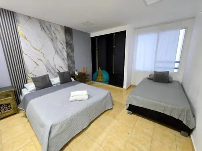 a bedroom with two beds and a window at Apto Vista Lateral Mar Piso 15 in Cartagena de Indias