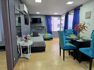 a living room with a table and blue chairs at Apto Vista Lateral Mar Piso 15 in Cartagena de Indias