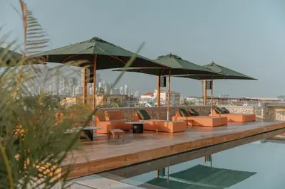 a deck with chairs and umbrellas next to a pool at Osh Hotel Cartagena in Cartagena de Indias