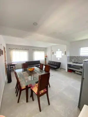 a dining room and living room with a table and chairs at Cabaña con piscina y Cerca al mar VILLA CONEJO in Juan de Acosta