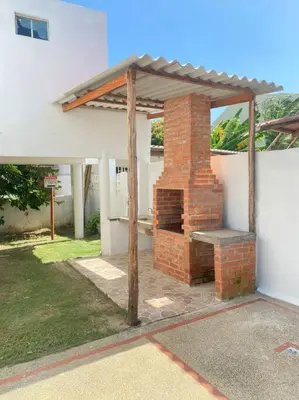 an outdoor brick fireplace with awning on a house at Cabaña con piscina y Cerca al mar VILLA CONEJO in Juan de Acosta