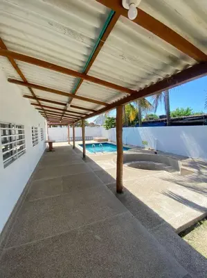 a patio with a roof over a swimming pool at Cabaña con piscina y Cerca al mar VILLA CONEJO in Juan de Acosta
