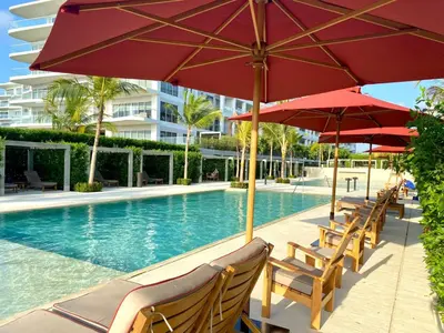 a pool with chairs and umbrellas next to a building at Espectacular frente al Mar- Morros Zoe - Playa Manzanillo Cartagena in Cartagena de Indias