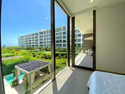 a bedroom with a balcony with a view of a building at Espectacular frente al Mar- Morros Zoe - Playa Manzanillo Cartagena in Cartagena de Indias