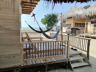 a hammock hanging from a building on the beach at Bungalow Palmar del Viento by AMAUNA in Moñitos