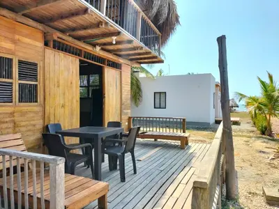 a wooden deck with a table and chairs at Bungalow Palmar del Viento by AMAUNA in Moñitos