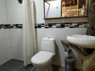 a bathroom with a toilet and a sink at Bungalow Palmar del Viento by AMAUNA in Moñitos