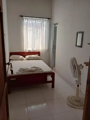 a bedroom with a bed and a window and a fan at Sol y Mar in Isla Fuerte
