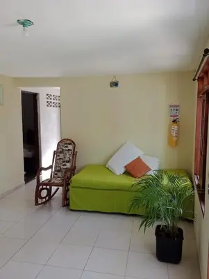 a green couch in a room with a chair at Sol y Mar in Isla Fuerte