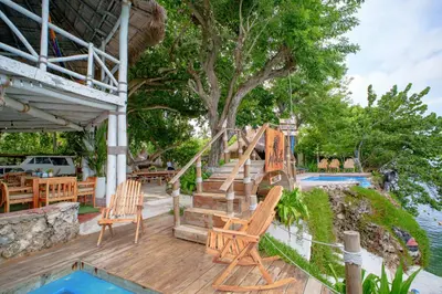 a deck with chairs and a staircase next to a pool at Isla Mulata, Islas del Rosario in Isla Grande