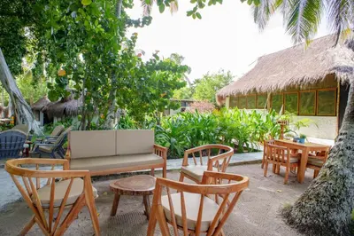 a patio with chairs and a table and a bench at Isla Mulata, Islas del Rosario in Isla Grande