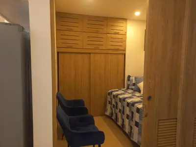 a bedroom with a bed and two blue chairs at Apto morroszoe 217A in Cartagena de Indias
