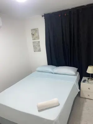a white bed in a room with a black curtain at Habitación cerca al aeropuerto 3 in Cartagena de Indias
