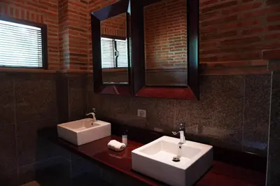 a bathroom with two white sinks and a mirror at Castillete Hotel & Beach Club in Tierra Bomba