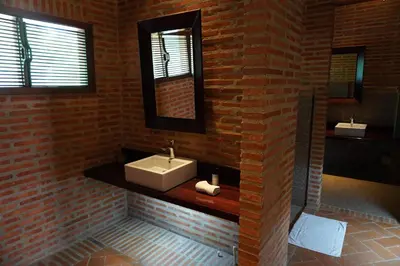 a bathroom with a sink and a brick wall at Castillete Hotel & Beach Club in Tierra Bomba
