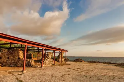 a building with a red roof next to the ocean at Castillete Hotel & Beach Club in Tierra Bomba