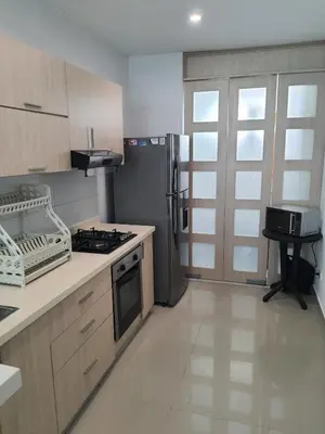 a kitchen with a stove and a refrigerator at Hermoso apartamento con piscina frente al mar - Primera Ensenada in Coveñas