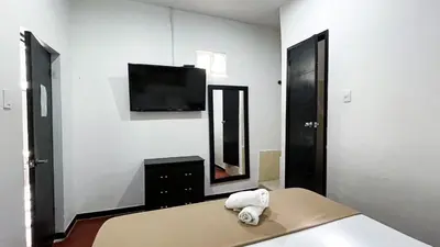 a bedroom with a bed and a tv and a mirror at HOSTEL M&H in Cartagena de Indias