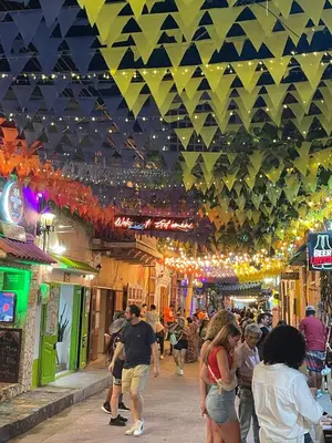 a group of people walking down a street in a market at HOSTEL M&H in Cartagena de Indias