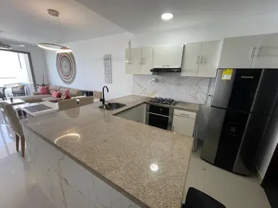 a kitchen with a black refrigerator and a counter top at Front beach apartment close to the Cartagena letters in Cartagena de Indias