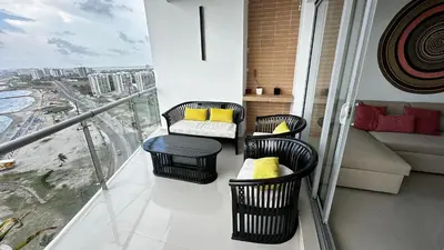 a balcony with chairs and a couch on a balcony at Front beach apartment close to the Cartagena letters in Cartagena de Indias