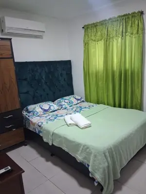 a bedroom with a bed with a green curtain at Apartamento turistico Mariangel in Cartagena de Indias