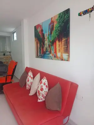 a red couch with pillows in a living room at Apartamento turistico Mariangel in Cartagena de Indias