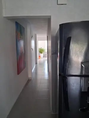 a hallway with a black refrigerator in a room at Apartamento turistico Mariangel in Cartagena de Indias