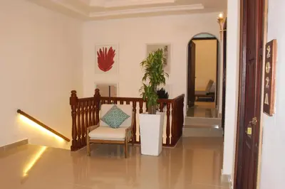a hallway with a chair and a potted plant at Hotel Casa Agustina in Cartagena de Indias