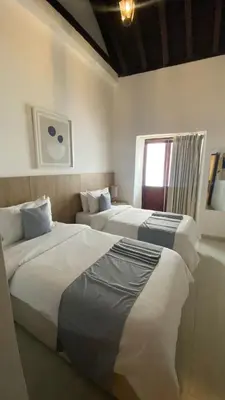 a hotel room with two beds and a window at Hotel Casa Agustina in Cartagena de Indias