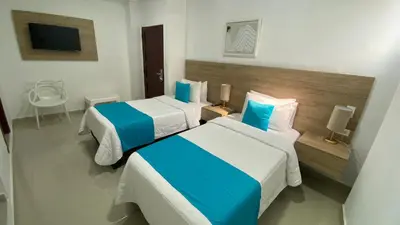 a hotel room with two beds and a television at Hotel Casa Agustina in Cartagena de Indias