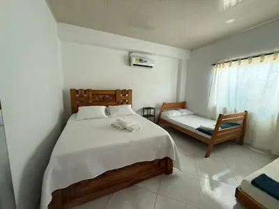 a bedroom with a large bed and a chair at Apartaestudio en Tolú - Itze solaris in Tolú