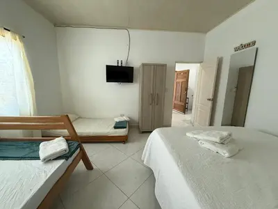 a bedroom with two beds and a tv on the wall at Apartaestudio en Tolú - Itze solaris in Tolú