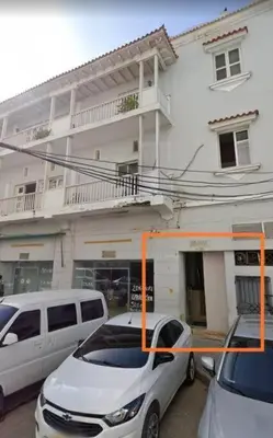 two cars parked in front of a white building at Apartamento centro histórico 303-2 in Cartagena de Indias