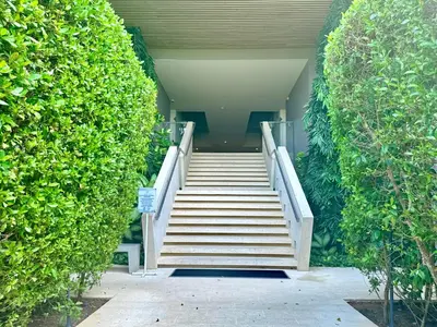 a stairway leading up to a building with a large green bush at Fantastic Loft/Beachfront+Pools in Cartagena de Indias