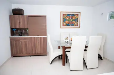 a dining room with a table and two white chairs at cabaña villa Oti 1 in Ciénaga
