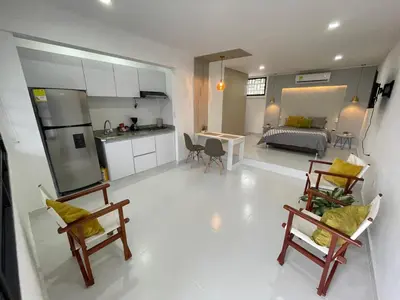 a living room and kitchen with chairs and a living room at Apartasuites Mardini in Cartagena de Indias