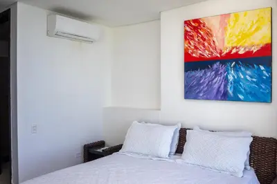 a bedroom with a bed and a painting on the wall at Apartamento frente al mar con vista única en Cartagena in Cartagena de Indias