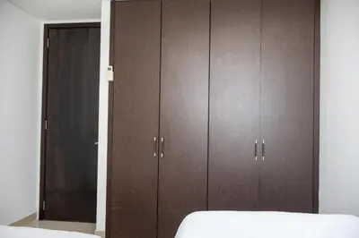 a bedroom with brown cabinets and a bed at Apartamento frente al mar con vista única en Cartagena in Cartagena de Indias