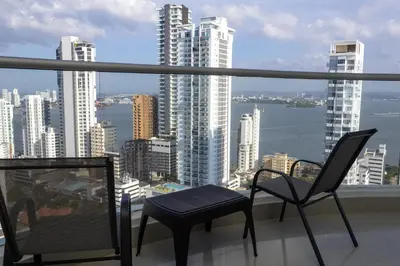 a balcony with two chairs and a view of the city at Apartamento frente al mar con vista única en Cartagena in Cartagena de Indias