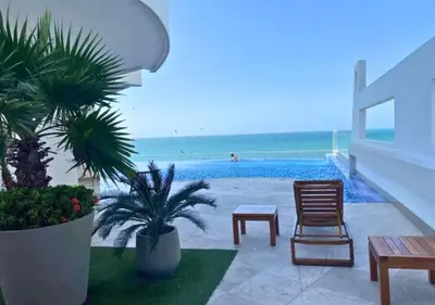 a resort patio with a pool and a table and chairs at Apartamento frente al mar con vista única en Cartagena in Cartagena de Indias