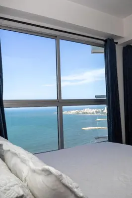 a bedroom with a large window overlooking the ocean at Apartamento frente al mar con vista única en Cartagena in Cartagena de Indias