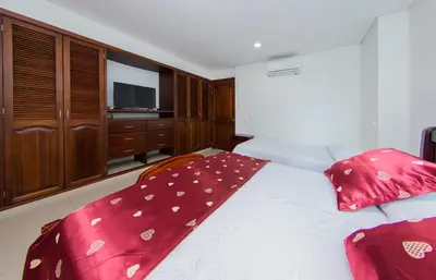 a bedroom with a bed with red pillows and a television at Torres del lago de 2 habitaciones, 1201 in Cartagena de Indias