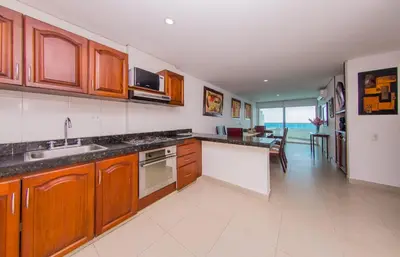 a kitchen with wooden cabinets and a view of the ocean at Torres del lago de 2 habitaciones, 1201 in Cartagena de Indias