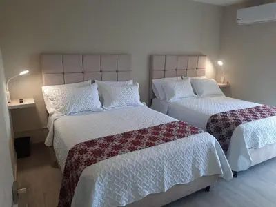 a bedroom with two beds with white and red sheets at Dominique Cartagena, Beautiful 2 Bedroom Apartment in Cartagena de Indias