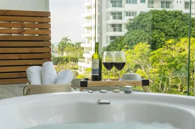 a bath tub with a bottle of wine and a glass at Dominique Cartagena, Beautiful 2 Bedroom Apartment in Cartagena de Indias
